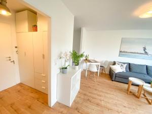 Una sala de estar con un sofá azul y una mesa. en HAVEN STUUV - Zentral mit Balkon, en Bremerhaven