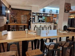a restaurant with wooden tables and chairs and a bar at Hotel Valérie in Montgenèvre