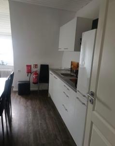 a kitchen with a white refrigerator and a table at Ferienwohnung Herzberg in Loxstedt