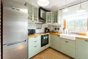 a kitchen with white cabinets and a refrigerator at Dom Stokrotka in Lipinki Łużyckie