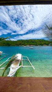 ein Boot auf dem Wasser am Strand in der Unterkunft Aviniel Cottage in Puerto Galera