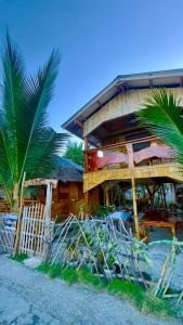 ein Gebäude mit einer Palme davor in der Unterkunft Aviniel Cottage in Puerto Galera