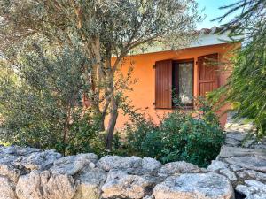 an orange house with a fence in front of it at Casa Giuliana in Funtana Meiga