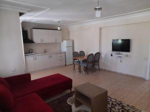 a living room with a red couch and a table at Aydın palace termal in İhsaniye