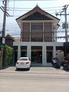 a white car parked in front of a building at The Wing Lanna Hotel in Chiang Mai