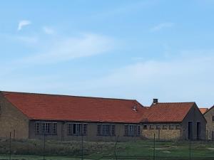 an old brick building with a red roof at Living Holiday in Middelkerke