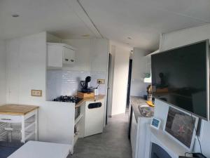 a small kitchen with white cabinets and a sink at Living Holiday in Middelkerke