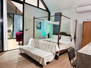 ein Schlafzimmer mit Himmelbett und Stuhl in der Unterkunft cloud & countyard in Mae Rim + 24 Fotos