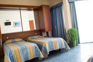Hotel Gabbiano في بورتو سان جورجيو: غرفة فندقية بسريرين ومرآة