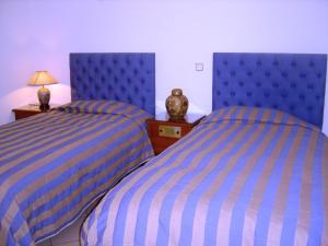 two beds sitting next to each other in a bedroom at Kalimera Hotel in Poros