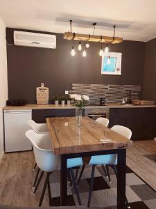 a kitchen with a wooden table and white chairs at Vikendica Niki - Village house with pool in Ćetojevići
