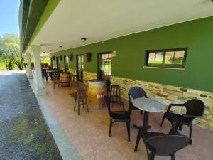 a restaurant with tables and chairs and a green wall at Fogar dos Antigos in Mazaricos