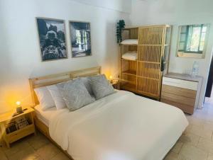 una camera da letto con un grande letto bianco con due cuscini di La Mirage a Nea Fokea