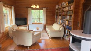 a living room with a couch and chairs and a tv at Blockhaus Ville in Thören +19 photos