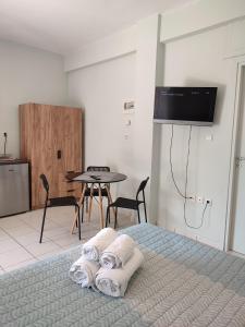 a bedroom with a bed and a table with towels at Kiki's cosy apartments in Nea Chili