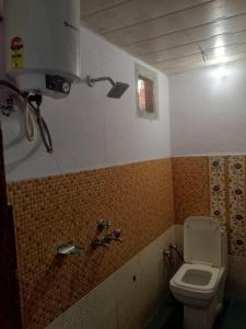 a bathroom with a toilet and a sink at Kanhaiya Hotel in Sonprayag