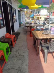 a restaurant with tables and chairs with umbrellas at Kanhaiya Hotel in Sonprayag