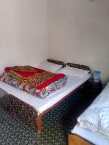 a bed with a blanket on it in a room at Kanhaiya Hotel in Sonprayag