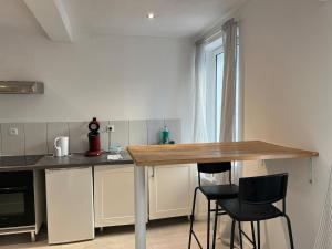 a kitchen with a table and two black chairs at Zen Studio Center Toulon in Toulon