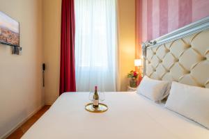 a bed with a bottle of wine and a glass on it at Residenza Conte di Cavour & Rooftop in Florence