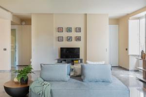 ein Wohnzimmer mit einem blauen Sofa und einem Fernseher in der Unterkunft Palazzo Valguarnera - Suites & Luxury Apartments in Palermo + 43 Fotos