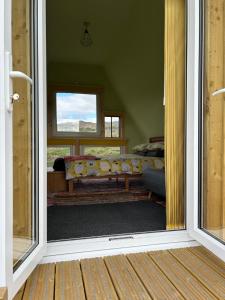 an open door to a living room with a couch at Keltic cabin off grid camping nc500 in Lochcarron