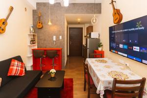 a living room with a table and some guitars on the wall at Velvet Vibe Chic Makati Stay Pool Gym 4034 in Manila