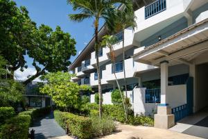 an exterior view of a building with palm trees at Phuket Island View Resort in Karon Beach