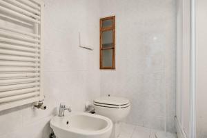 a white bathroom with a toilet and a sink at FinestraNelBorgo best position Private parking in Portovenere +11 photos