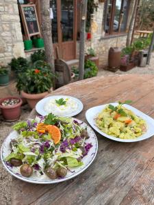 three plates of food on a wooden table at Kantina & Ferma Dukat in Vlorë