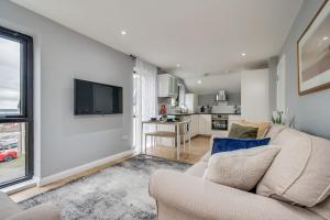 a living room with a couch and a tv at City Line Apartment 5 in Carnmoney