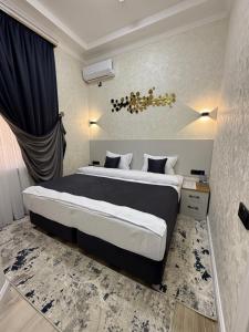a bedroom with a large bed with black and white sheets at Гостевой дом Nifal in Samarkand