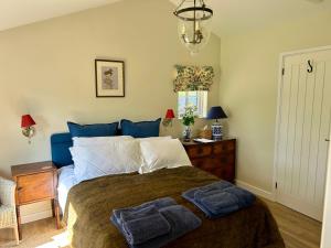 a bedroom with a bed with two towels on it at Giffords Hall Garden Room in Shimpling