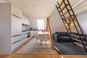 Ferienwohnung Strom ahoi - premium - modern - inkl Stellplatz - 200m zum Alten Strom - Wasserblick في فارنمونده: مطبخ وغرفة معيشة مع درج وطاولة