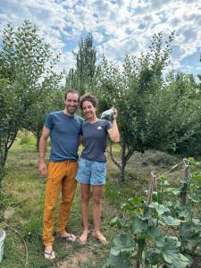 a man and a woman standing in a garden at Dan guest house in Pokrovka