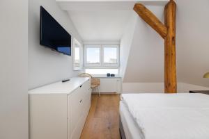 Ferienwohnung Strom ahoi - premium - modern - inkl Stellplatz - 200m zum Alten Strom - Wasserblick في فارنمونده: غرفة نوم بها سرير وتلفزيون على الحائط +23 صورة