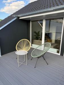 two chairs and a table on a deck at 3-Zimmer-Wohnung in Hamburg am Flughafen in Hamburg