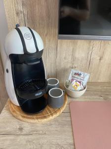 a coffee maker sitting on a table with cups at Sorelle Misceo in Alberobello