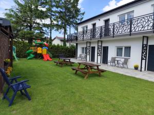 a backyard with picnic tables and a playground at Morska Fala in Sarbinowo