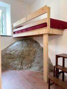 a bunk bed in a room with a rock at La Casetta della Pietra in Montale