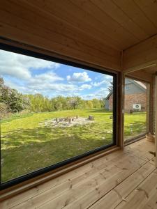 a large window in a room with a view of a yard at Dla Pary - Sauna, Joga, Masaż, Jezioro in Mikołajki