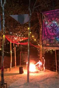 a group of people sitting around a fire at night at Bamboo leaf Homestay in Meppādi +1 photo