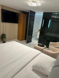 a bedroom with a large white bed and chairs at Luxury Old Town Rab Studio Apartments in Rab