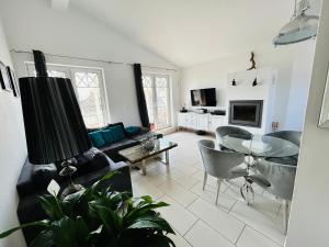 a living room with a couch and a table and chairs at Wohnung Hafenblick in Zingst