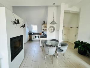 a living room with a table and chairs and a television at Wohnung Hafenblick in Zingst