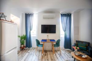 a living room with a table and blue curtains at Studio tout équipé, plein centre in La Ciotat
