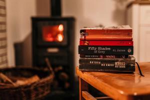 a stack of books sitting on top of a table at Hiška pri Paulu in Dobrovnik