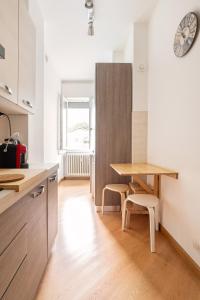 una cucina con un tavolo e sedie in legno in una stanza di Maison Gigi a Lecco