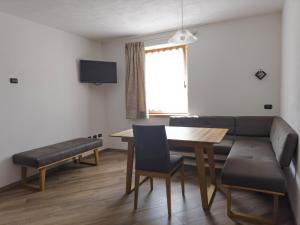 a living room with a table and a couch at Appartamenti LITEGOSA casa vacanza 3 in Panchia
