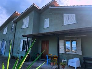 una casa grigia con un tavolo e sedie di fronte di Casetta a Cavarretta a SantʼAgata di Militello